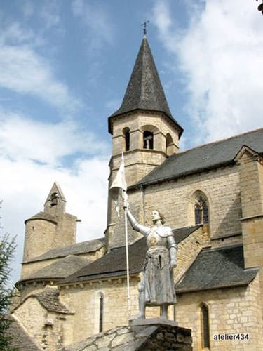Villeneuve d'Aveyron Church with the statue of Joan of Arc