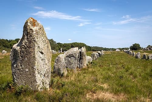 Le Ménec alignments in Carnac feature 11 converging rows of 1,100 menhirs, extending over a strip of land measuring 1.2 kilometers in length and 100 meters in width, oriented from west to east