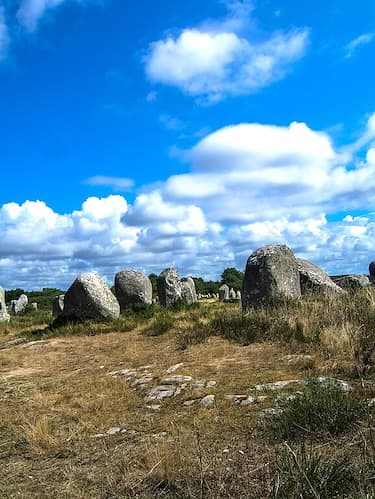 Le Ménec alignments in Carnac feature 11 converging rows of 1,100 menhirs, extending over a strip of land measuring 1.2 kilometers in length and 100 meters in width, oriented from west to east