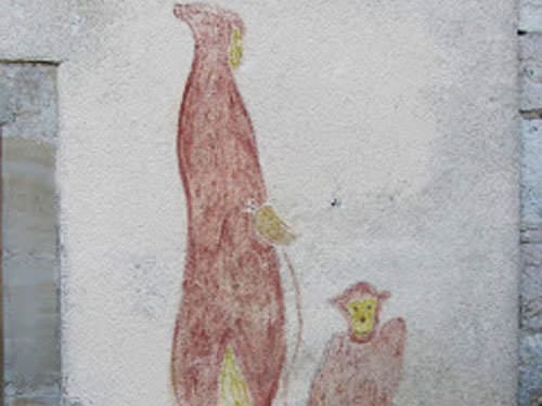 Monk and his monkey on a village wall