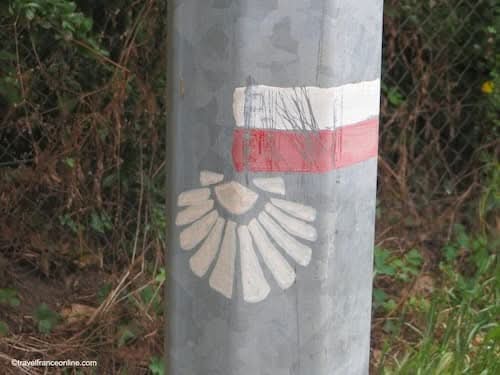 Red-and-white GR sign and scallop shell along the Camino trails